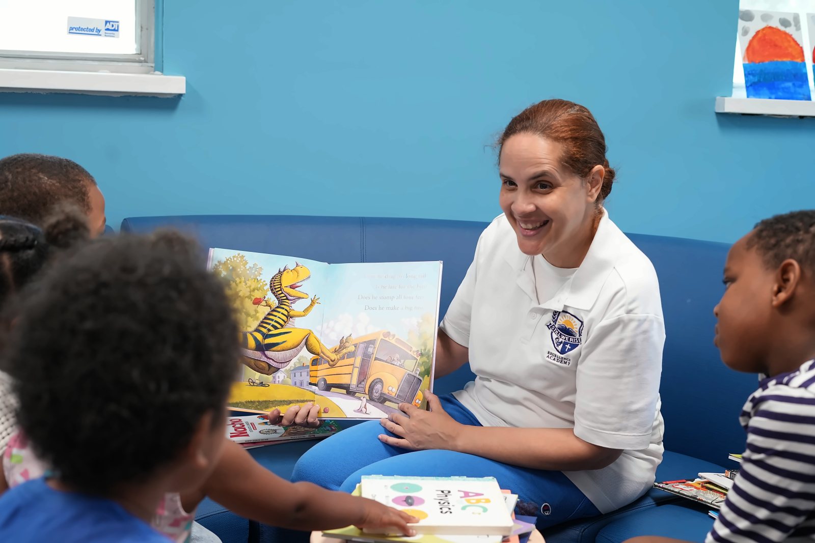 Maestra Nuñez smiling as she reads a picture book to a group of SWREA students